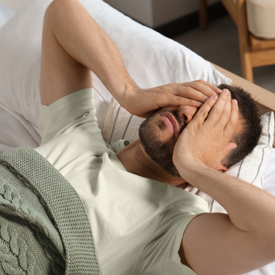 Sleepless man lying in bed at home