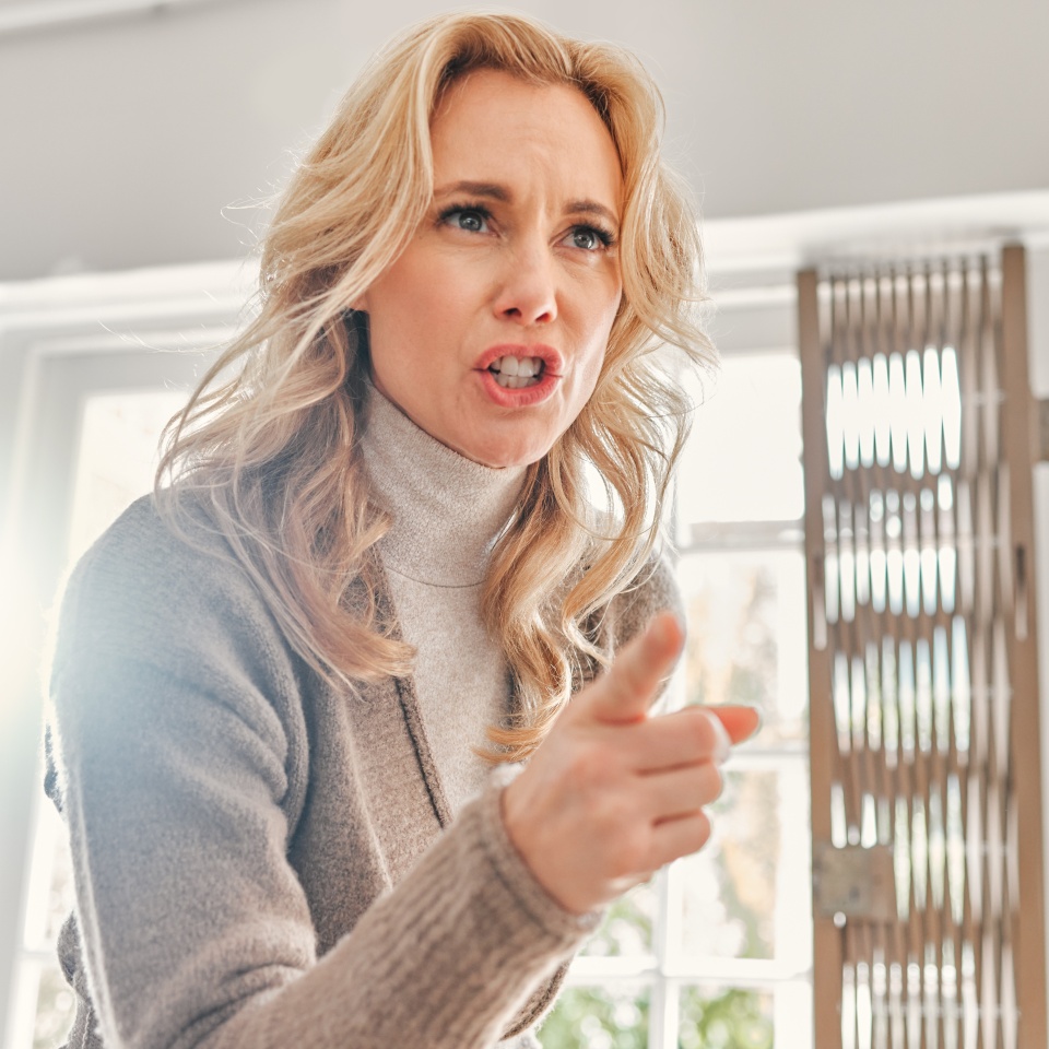 House, upset and scolding of woman, angry and pointing with finger for discipline, argument and living room. Furious, mad and frustrated with hand in lounge, talking and fight in home and conflict