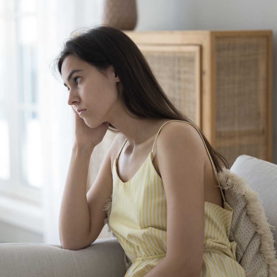 Boring. Sad unhappy tired teen girl sit on couch propping head with hand feel dull spending summer day at home alone suffer from depression loneliness love problems breakup lost in negative thoughts