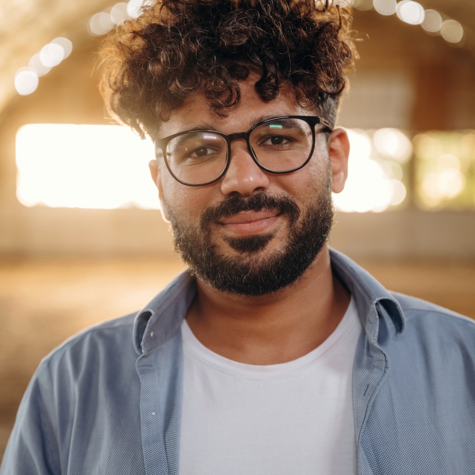 Cheerful man in glasses is in hangar.