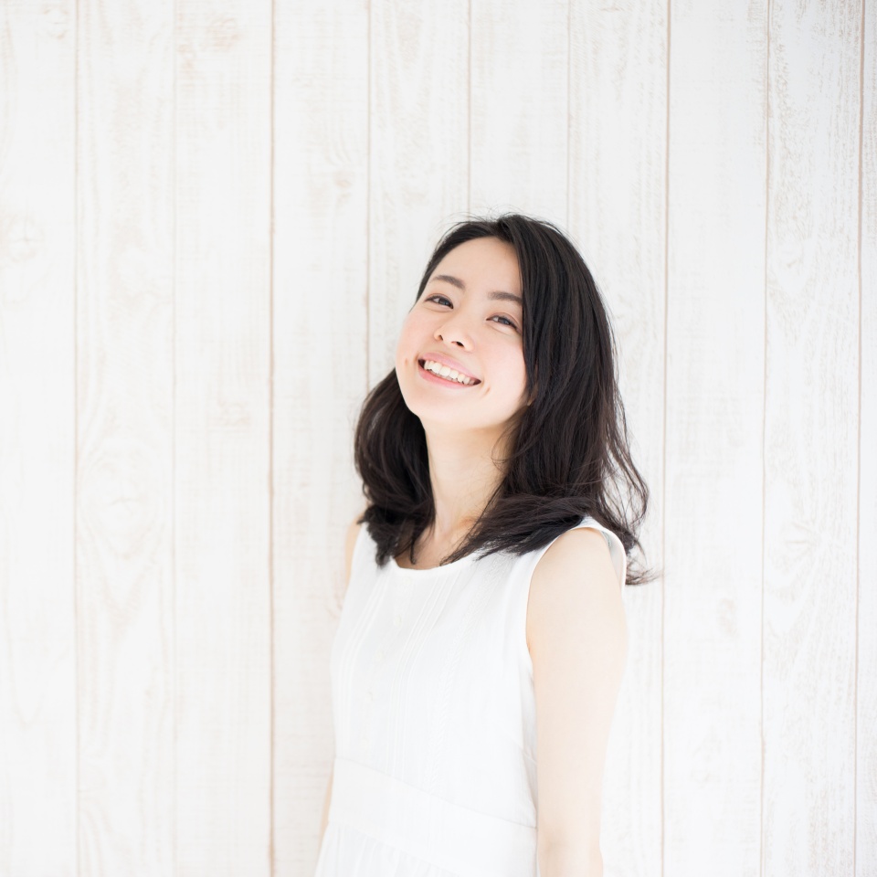 beautiful young woman against white wooden wall