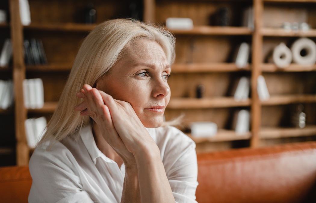 Stressed sad tired exhausted caucasian middle-aged mature businesswoman freelancer relaxing on the couch sofa, thinking about family marriage work problems at work office